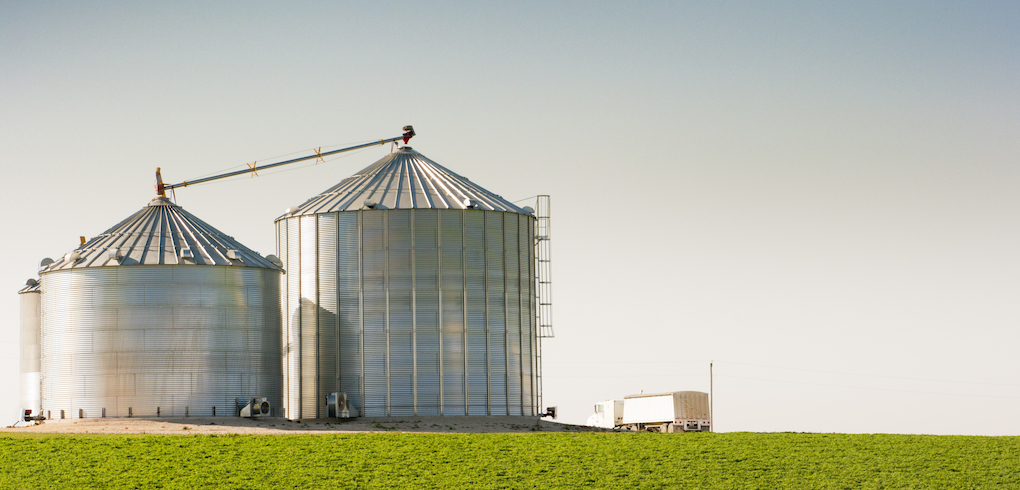 Grain Silo Bins and Truck in Farm Field Agricultural Landscape